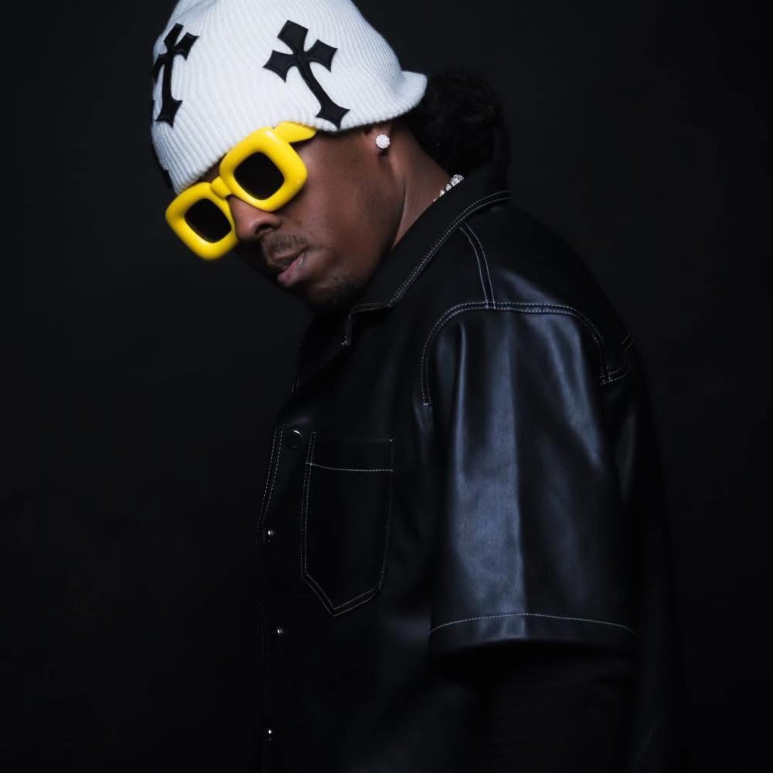 A1 Flow in a black leather editorial portrait with yellow glasses